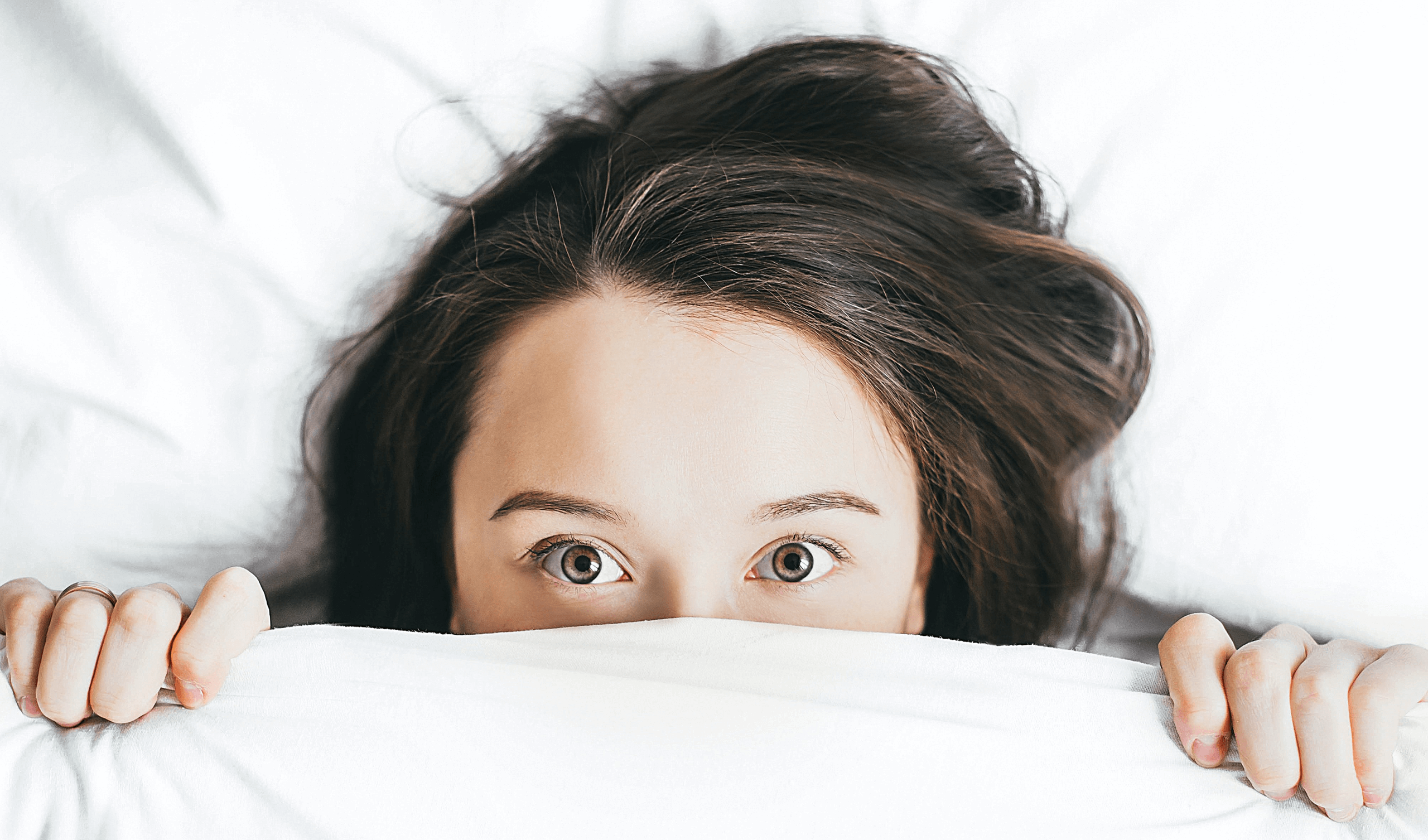 Girl peeking out of bed